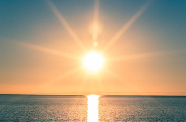 Sunset over Ocean - Bright Orange Sun Setting on Beautiful Blue Water