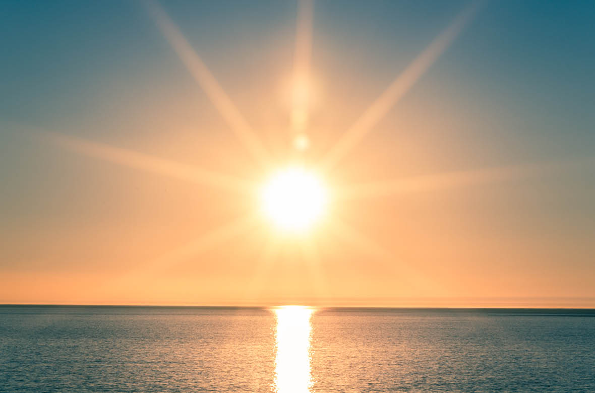Sunset over Ocean - Bright Orange Sun Setting on Beautiful Blue Water