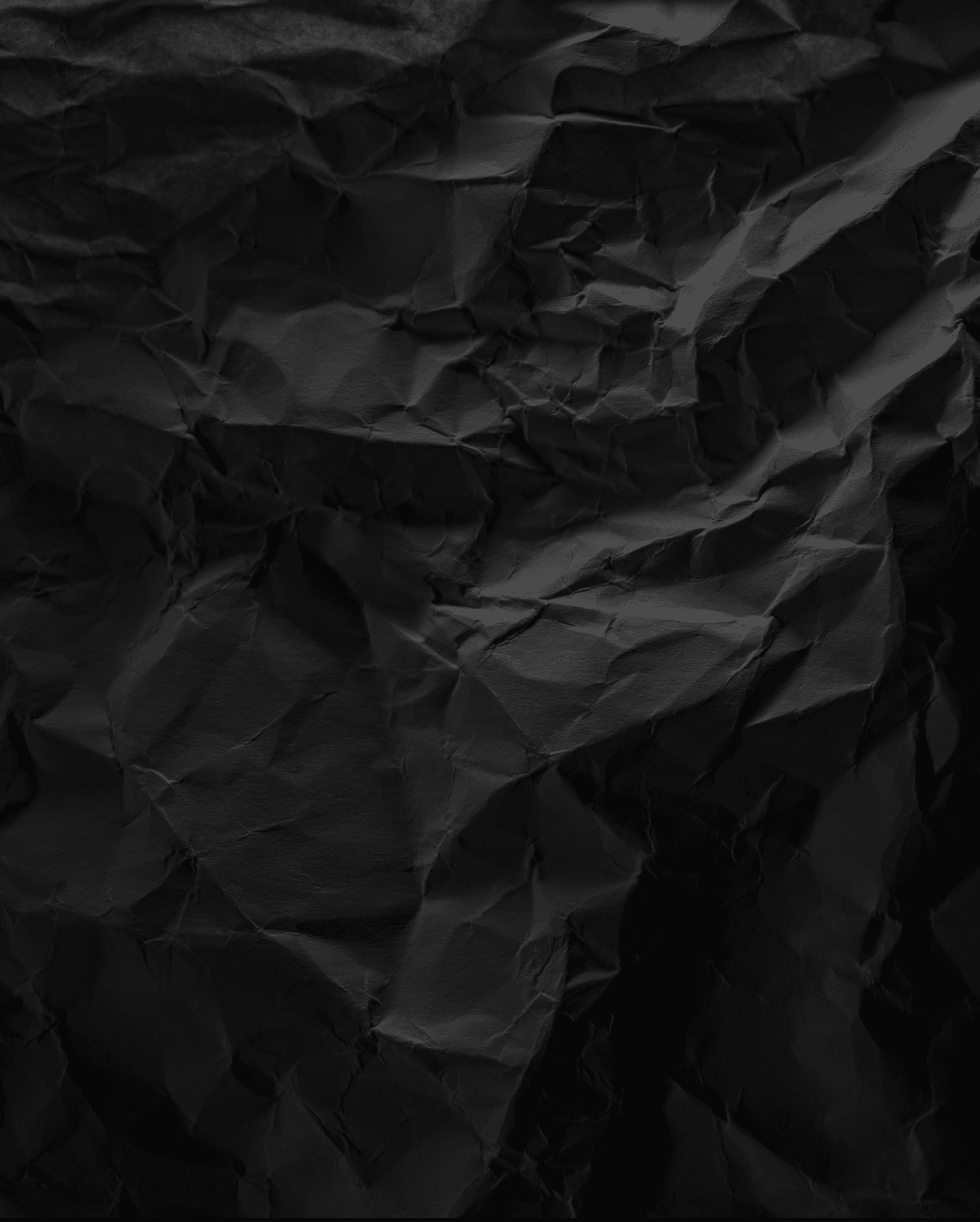 Black crumpled paper texture in low light background