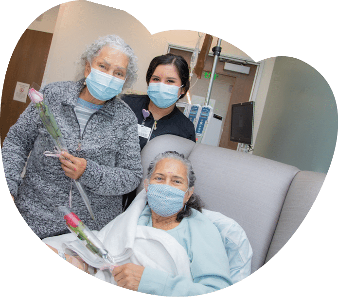 Sonnia Gutierrez (patient) and Teresa de Santos (patients mother) receive a rose from nurse Viridiana Rosas - Mother's Day Roses 2022 - HC3 Keck Medicine of USC